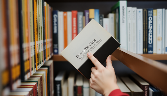 A person thoughtfully choosing a single book from a shelf