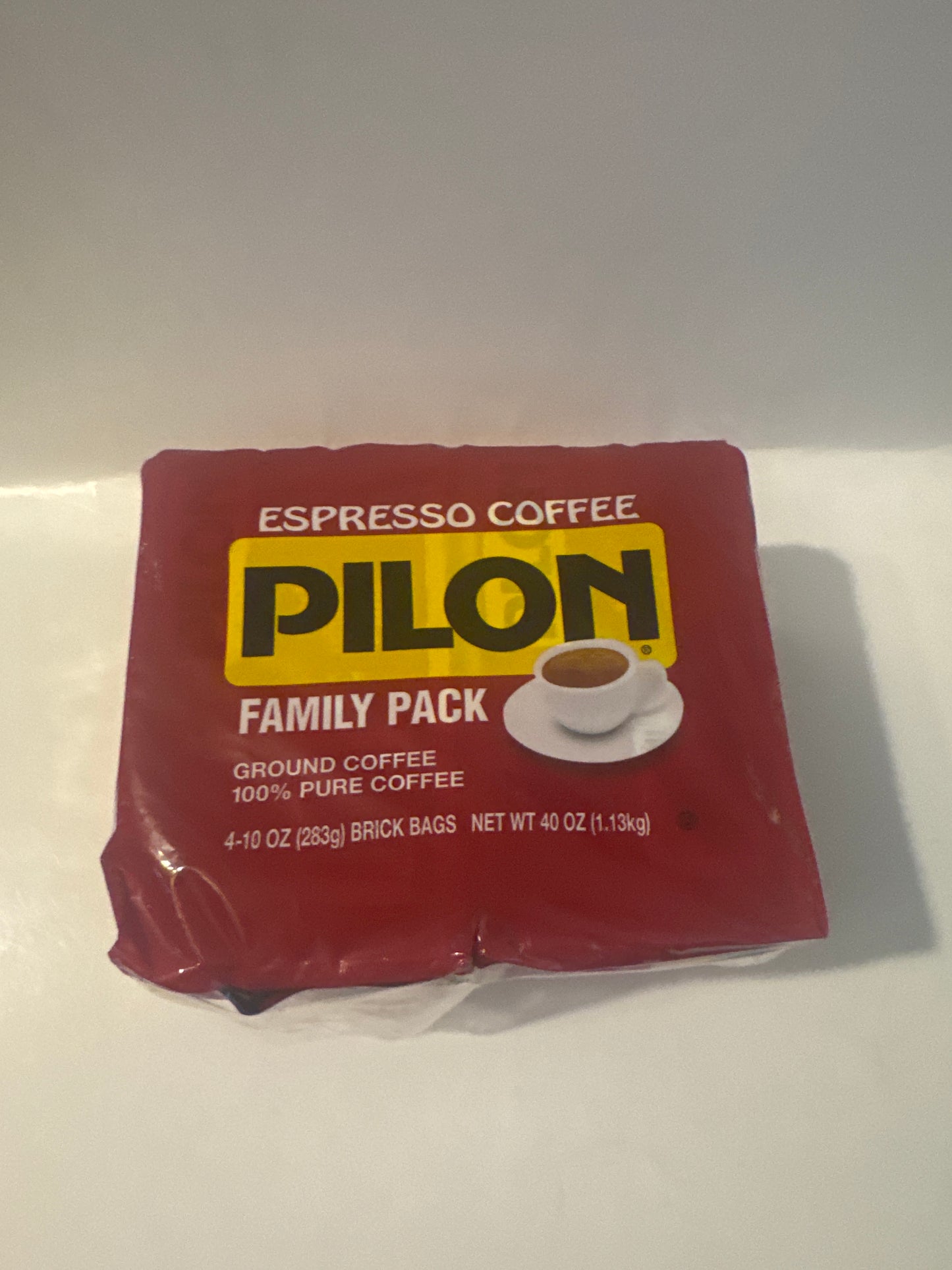 Vacuum-sealed Café Pilon espresso coffee on kitchen counter with moka pot