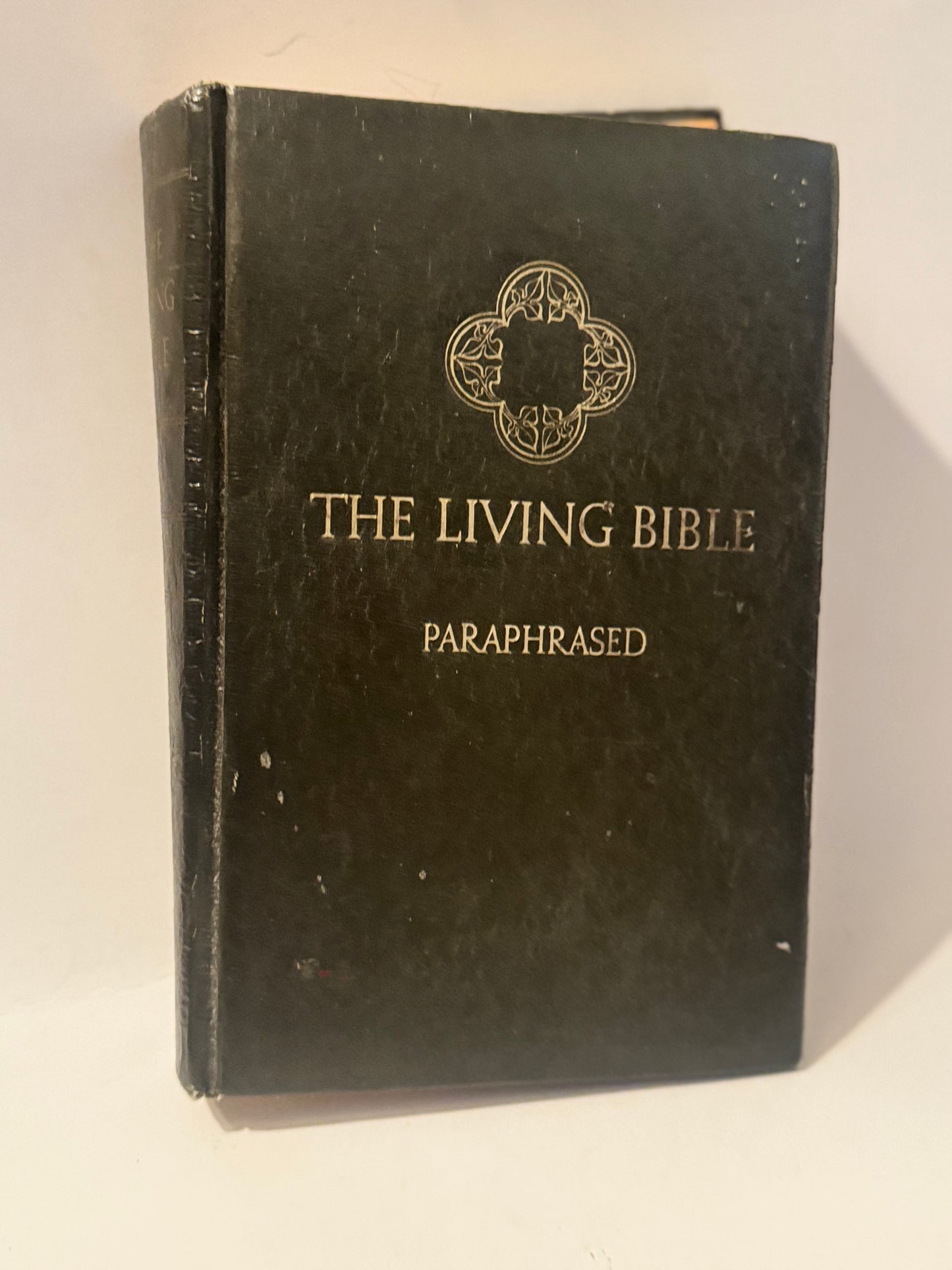 Black hardcover of The Living Bible: Paraphrased, featuring gold lettering and a decorative emblem.