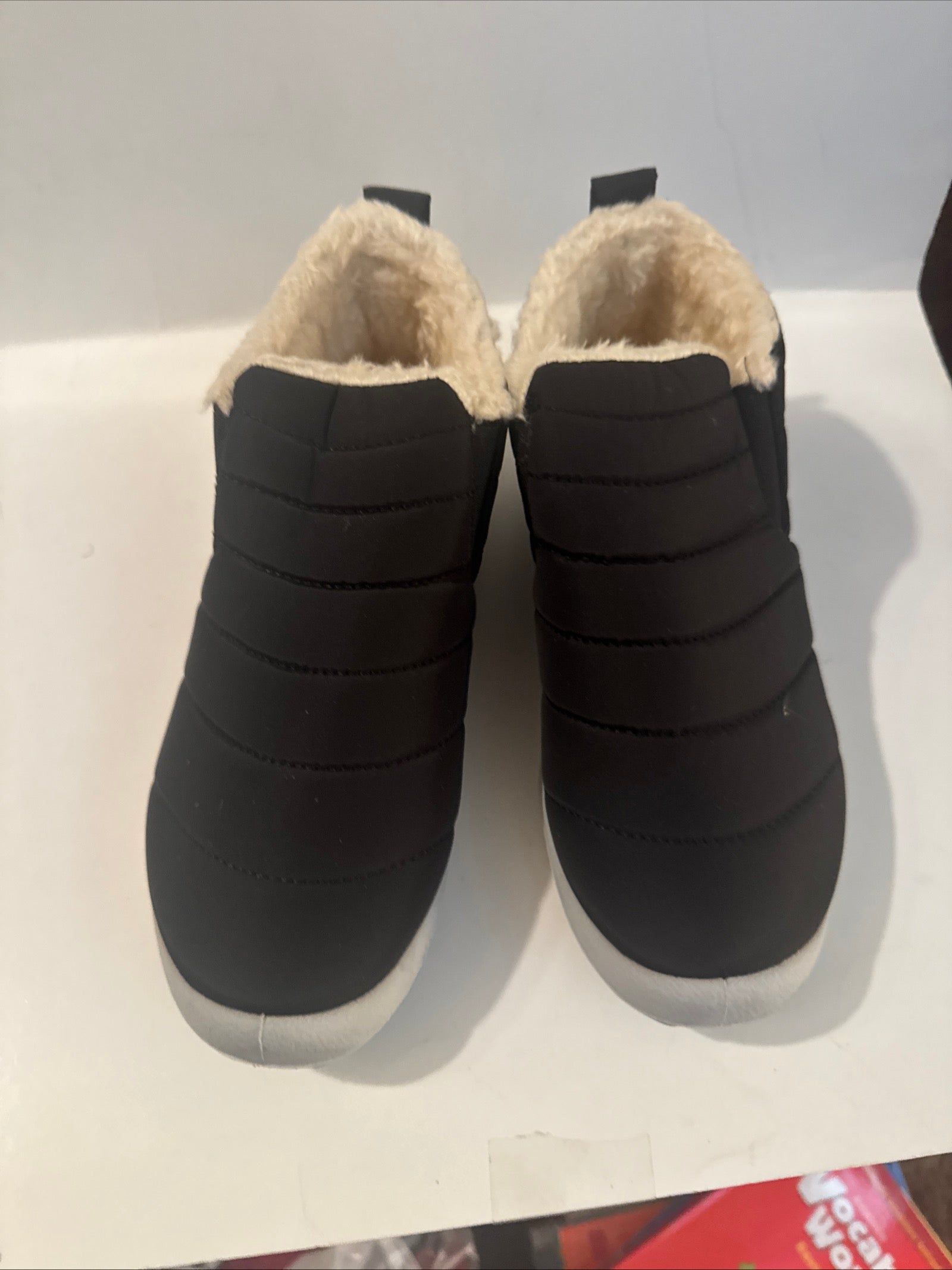 Black quilted winter slippers with faux fur lining and soft sole for adults