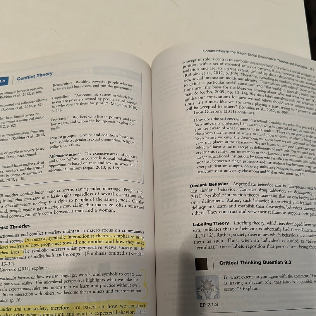 Open book showing pages of Human Behavior in Macro Social Environment book with text on conflict theory and deviant behavior