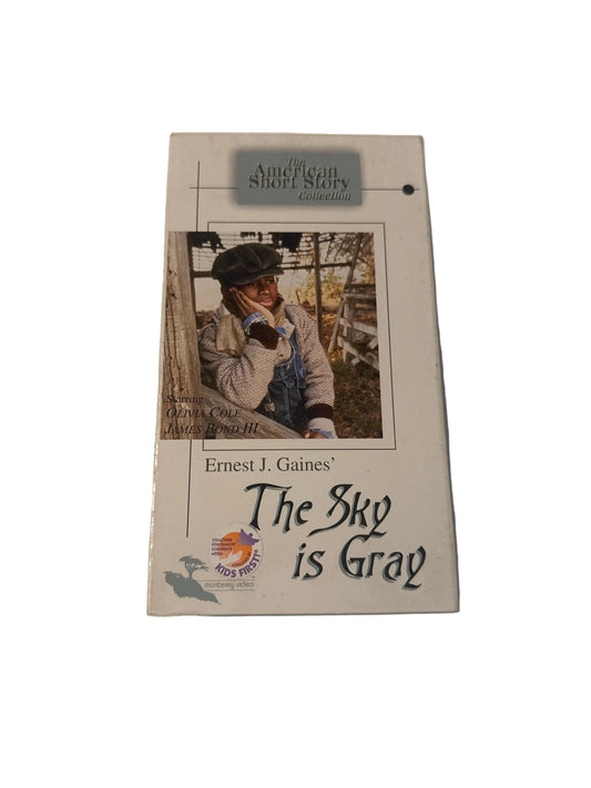 A VHS tape of the book 'The Sky is Gray' by Ernest J. Gaines, featuring a cream-colored cover with a central photograph of a man lying on the ground and stylized black text.
