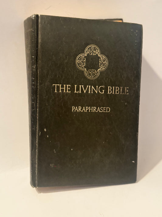 Black hardcover of The Living Bible: Paraphrased, featuring gold lettering and a decorative emblem.