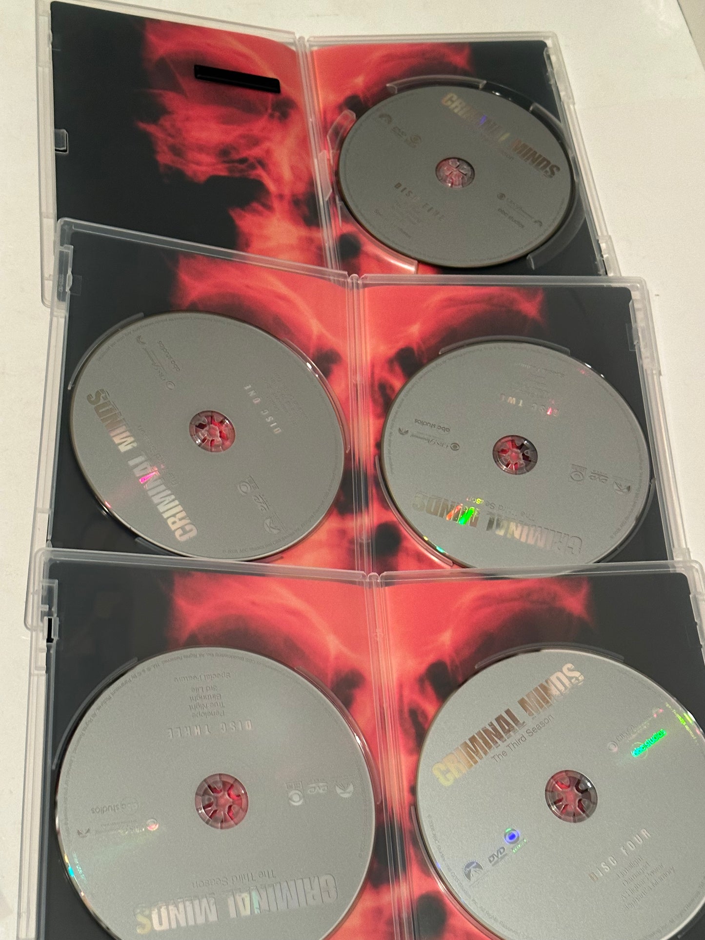 Criminal Minds Season 3 DVD exclusive set showing multiple discs in clear cases with fiery background