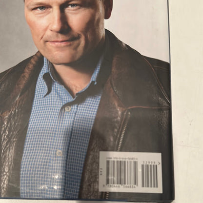 Close-up of a man wearing a leather jacket on the back cover of a David Baldacci thriller novel