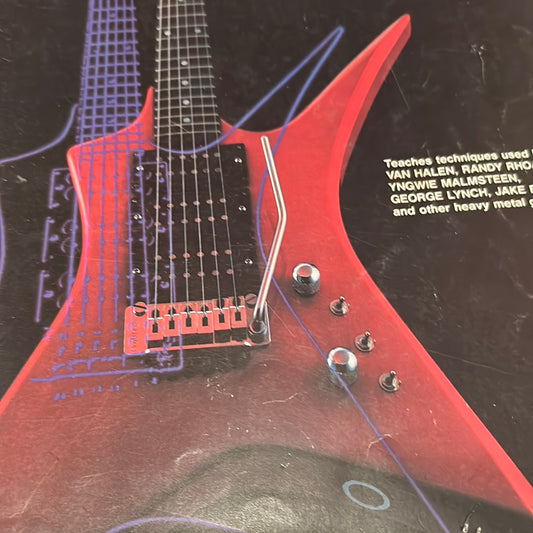 EveryMailBox heavy metal guitar lessons featuring a red electric guitar close-up with detailed strings and controls