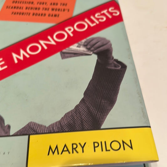 Cover of Monopoly board game scandal book by Mary Pilon showing a hand holding money and bold red title