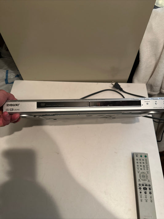 Sony DVD CD player held in hand with remote control on table, buy used DVD CD player online