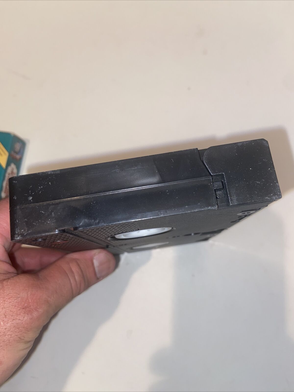 EveryMailBox hand holding a worn black Thomas The Tank Engine rare VHS tape showing top edge and scuffs