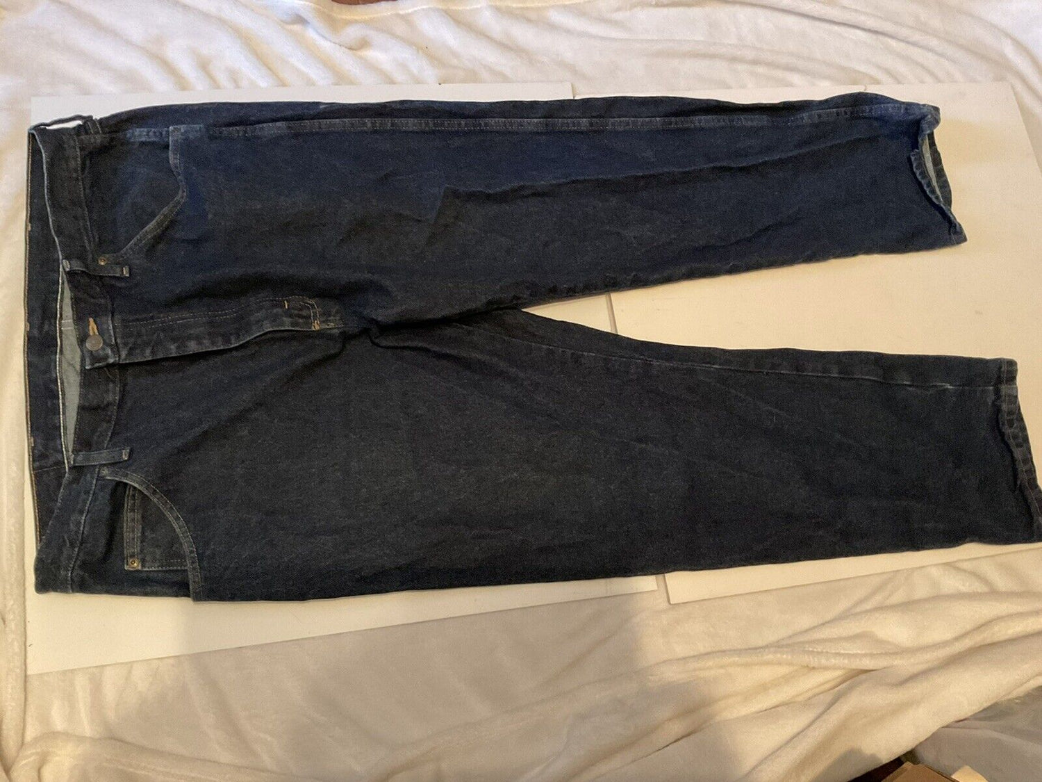 Wrangler relaxed fit jeans men dark indigo straight leg five pocket jeans laid flat on bed